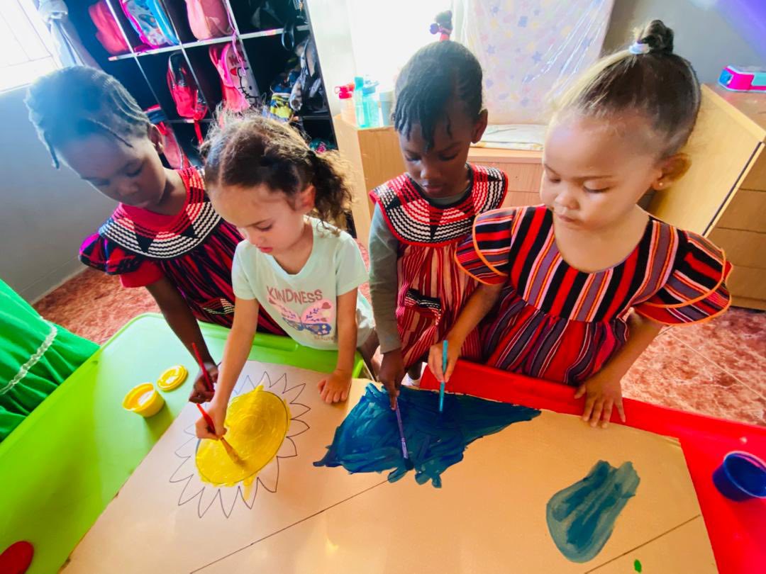 Children in cultural dress doing art